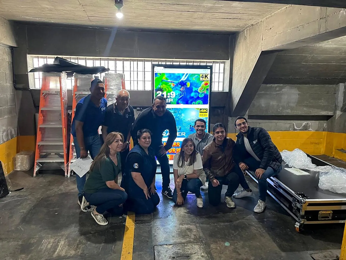 Equipo y cliente junto a pantalla LED entregada a Impacto Visual