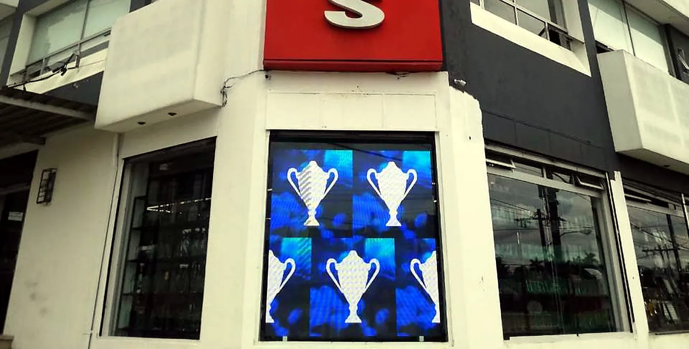 Fachada de Munditrofeos con pantalla LED instalada en su vitrina de esquina
