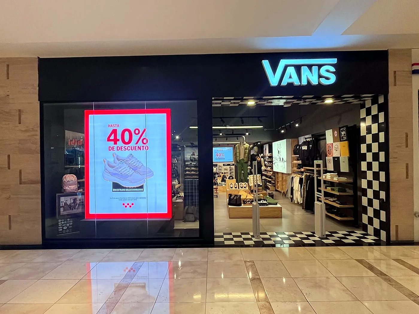 Fachada de la tienda VANS en C.C. Miraflores con pantalla LED de promociones en la vitrina